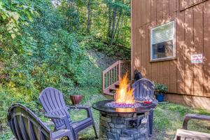 a patio with two chairs and a table with a fire pit at Cozy Cabin with Mountain Views Near SkyLift Park! in Gatlinburg