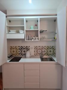 una cocina con armarios blancos y fregadero en Casa D'Amato Salerno, en Salerno