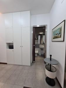 Habitación blanca con mesa y baño. en Casa D'Amato Salerno, en Salerno