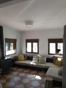 a living room with a couch and windows at Puerta Laguna - Casa con parcela in Hita