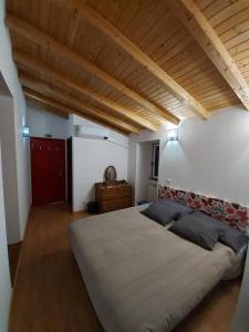 un grande letto in una camera da letto con soffitto in legno di Sotam Country House EN342 a Góis