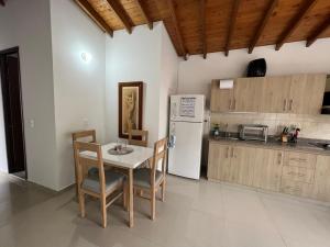 eine Küche mit einem Tisch und einem weißen Kühlschrank in der Unterkunft Cómodo apartamento completo en Envigado in Envigado