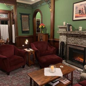 sala de estar con 2 sillas y chimenea en The KirkHouse Bed and Breakfast, en Friday Harbor