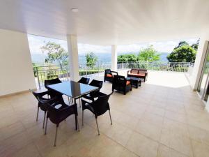 a dining room with tables and chairs and a balcony at CasaMIA Hotel Boutique - Villeta in Villeta