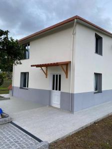 une grande maison blanche avec une grande allée. dans l'établissement Casa da Nora, à Póvoa de Lanhoso