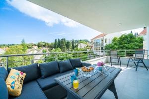 - un salon avec un canapé et une table sur un balcon dans l'établissement Blue Bay Apartment, à Dubrovnik