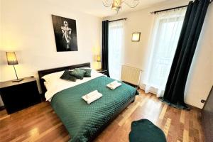 ein Schlafzimmer mit einem großen grünen Bett mit zwei Handtüchern darauf in der Unterkunft Exclusive PENTHOUSE near CityCenter 120m2 +NETFLIX in Krakau