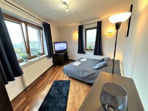 Schlafzimmer mit einem Bett, einem Tisch und Fenstern in der Unterkunft Exclusive PENTHOUSE near CityCenter 120m2 +NETFLIX in Krakau