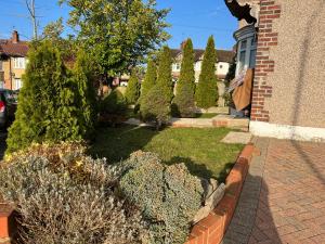 een tuin met struiken en bomen in een huis bij TJ Homes - Entire place for 5 Guests - London in Ruislip