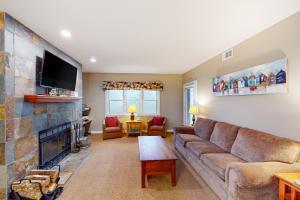 a living room with a couch and a fireplace at Winterplace G101 in Ludlow