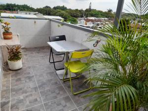 una mesa y sillas en un balcón con plantas en apartaestudio terraza Romantico #14, en Cali