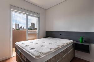 Un dormitorio con una cama grande y una ventana en VA26 - Apartamento Luxuoso com Varanda Gourmet na Vila Carrão, en São Paulo