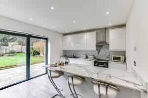 a kitchen with a marble counter top and a large window at Valley house in Biggin Hill