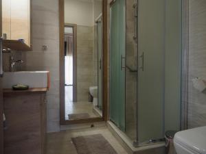 een badkamer met een glazen douche en een toilet bij Melissinos Beachfront Apartments in Kómi