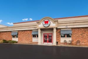 un edificio con una puerta roja y un cartel en él en Best Western St Catharines Hotel & Conference Centre, en St. Catharines