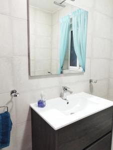 a white bathroom with a sink and a mirror at Modern, spacious and bright apt in centre of Malta in Mosta