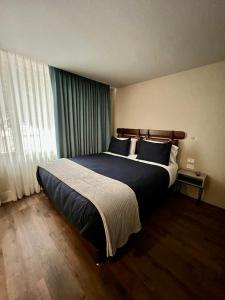 a bedroom with a large bed and a large window at Grace Chapinero in Bogotá