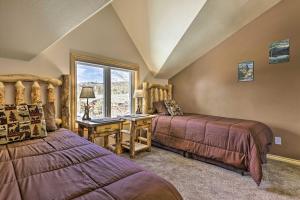een slaapkamer met twee bedden, een bureau en een raam bij Walk to Grand Lake Riverfront Gem with Fireplace! in Grand Lake