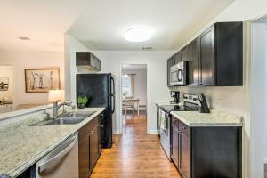 a kitchen with stainless steel appliances and wooden floors at Bright Hinesville Home, 43 Mi to Savannah! in Hinesville