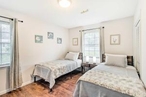 1 dormitorio con 2 camas y 2 ventanas en Bright Hinesville Home, 43 Mi to Savannah!, en Hinesville