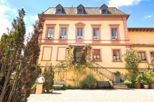 a large yellow building with stairs in front of it at Hotel Villa Königsgarten in Siebeldingen