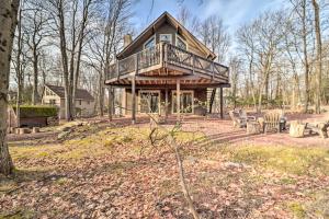 a large house with a deck on a hill at Lake Harmony Home with Game Room and Fire Pit! in Lake Harmony