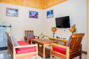 a dining room with a table and chairs and a television at Saline Hot Spring Resort นำ้พุร้อนเค็ม รีสอร์ท 