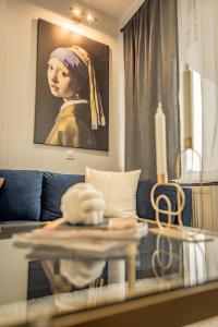 Apollo's Apartment on Radio City Midas Home في سلانيك: غرفة معيشة بها أريكة زرقاء و لوحة