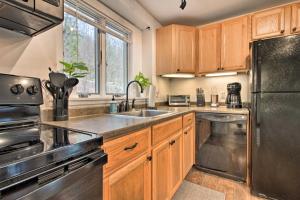 a kitchen with wooden cabinets and a stainless steel refrigerator at Cozy Killington Retreat about 5 Mi to Ski Resort in Killington