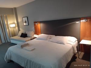 una habitación de hotel con una gran cama blanca en una habitación en Buenos Aires Apartamento en Buenos Aires
