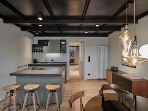 uma cozinha com um balcão e bancos num quarto em Parcloft em Merano