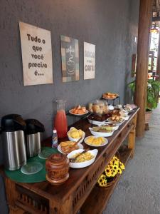 a buffet of food on a wooden table at Chalés e Suítes Campos de São João in Palmeiras +93 photos