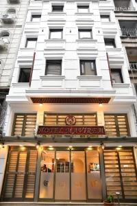 un bâtiment blanc avec un magasin devant lui dans l'établissement Hotel Mavirem, à Istanbul