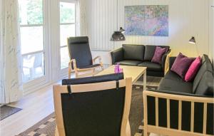 a living room with a couch and a table and chairs at Awesome Home In Aakirkeby With Wifi in Vester Sømarken