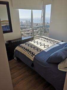 a bedroom with a bed and a large window at Depto Valparaíso con Vista al Mar y a la Bahía de Valparaíso in Viña del Mar
