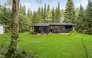 eine Hütte im Wald mit einem grünen Hof in der Unterkunft Pet Friendly Home In Kolind With Kitchen in Kolind