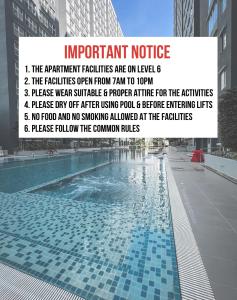 a sign next to a swimming pool in a city at SUWAN Guesthouse A06 - 2BR Apartment with Pool Near UKM in Kajang