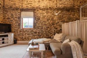 ein Wohnzimmer mit Sofa und Ziegelwand in der Unterkunft Randell's Mill - Adelaide Hills - Romantic Loft Stays in Gumeracha