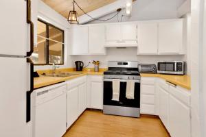 uma cozinha com armários brancos e um forno com placa de fogão em 2195-Slopeside Views Chalet home em Big Bear Lake