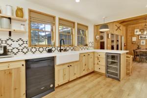 een keuken met houten kasten en een grote wastafel bij 2172-Bow Canyon Cabin home in Big Bear Lake