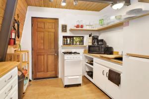uma cozinha com electrodomésticos brancos e uma porta de madeira em 1946-Wolf Cub Cabin home em Big Bear Lake