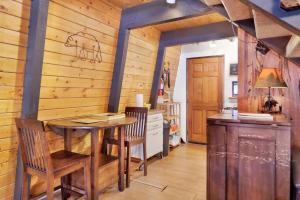 uma sala de jantar com uma mesa e cadeiras e paredes de madeira em 1946-Wolf Cub Cabin home em Big Bear Lake