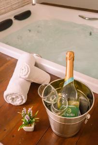 a bottle of champagne and glasses in a bucket next to a tub at Condominio Luna Rossa in Morro de São Paulo