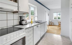a white kitchen with a sink and a stove at Beautiful Home In Svaneke With Kitchen in Svaneke +17 photos