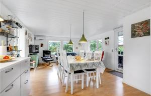 a kitchen and dining room with a table and chairs at 2 Bedroom Lovely Home In Sæby in Sæby