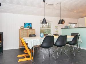 FjerbækにあるHoliday Home Lyngvej IVのダイニングルーム(テーブル、黒い椅子付)
