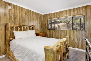 um quarto com paredes de madeira e uma cama com uma janela em 2160-The Malabear Cabin home em Big Bear City
