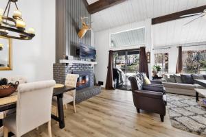 uma sala de estar com lareira e uma mesa e cadeiras em 2125-Switzerland Slopes townhouse em Big Bear Lake