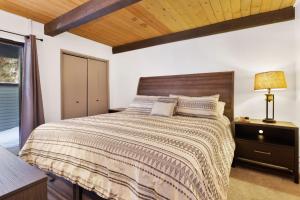 a bedroom with a large bed with a wooden ceiling at 2125-Switzerland Slopes townhouse in Big Bear Lake