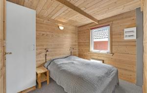 ein Schlafzimmer mit einem Bett in einem Holzzimmer in der Unterkunft 2 Bedroom Nice Home In Hemmet in Hemmet